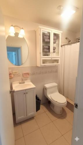 a bathroom with a toilet and a sink and a mirror at Casita Patz Ensenada in Ensenada