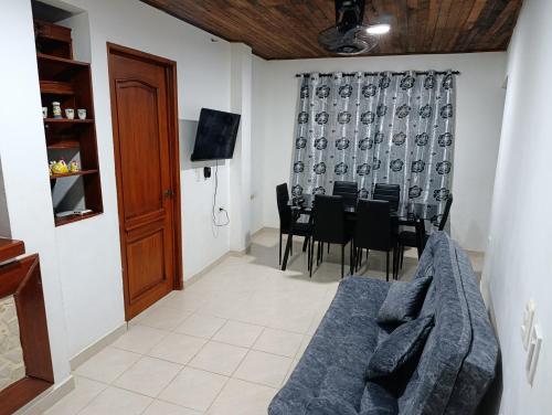 a living room with a couch and a table and chairs at Glamar Apartamento in Arboletes