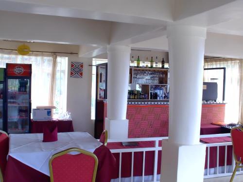 a restaurant with a table and chairs and a bar at Kivu Hotel Resort in Kibuye