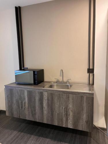 a kitchen with a sink and a microwave on a counter at HUNICO HOTEL in Tulancingo