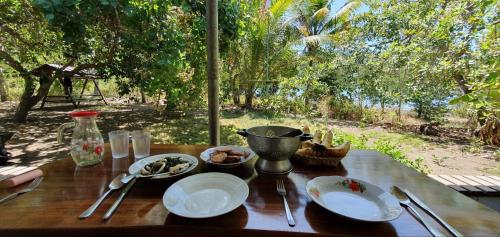 a wooden table with plates of food on top of it at Arche Noah in Kalabahi