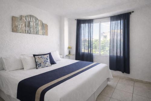 a bedroom with a large bed and a window at Departamento en Marina Diamante con lago y alberca in Acapulco
