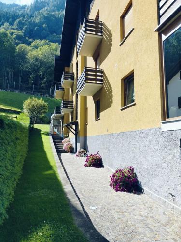 a building with stairs and flowers in front of it at Ai Volardi Apartment in Torre di Santa Maria