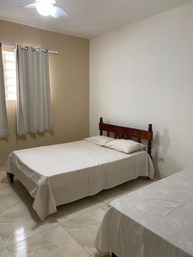 a bedroom with two beds and a window at Casa Ampla e aconchegante Limoeiro in Limoeiro