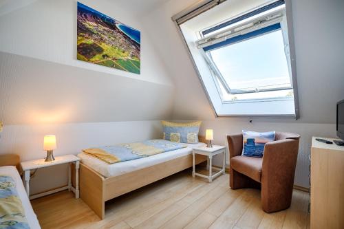 a bedroom with a bed and a window and a chair at FH Luisenlund im Ostseebad Prerow in Prerow