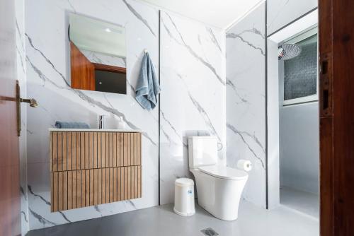 a white bathroom with a toilet and a sink at OIKOS SKMT in Sourotí