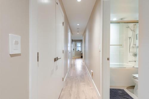 a hallway of a bathroom with a toilet and a sink at Modern Bright Suite Self Check-In in North Vancouver