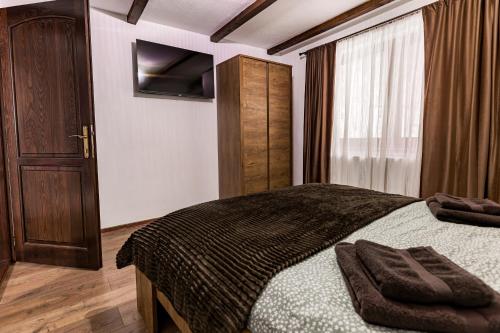 a bedroom with a large bed and a window at Cabana lui Matei in Borlova