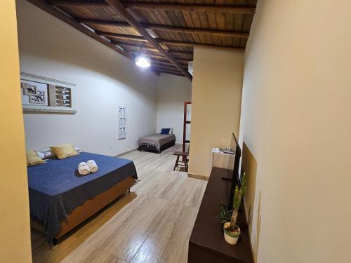 a bedroom with a bed and a couch in a room at Suíte Bem Te vi in Porto Seguro