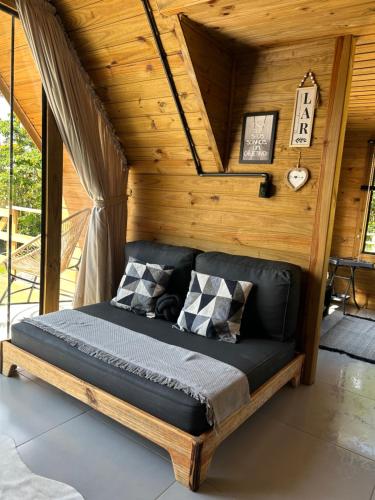 a bed in a room with wooden walls at Chalé aconchegante em madeira in Schroeder