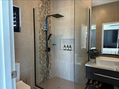 a bathroom with a shower and a sink at Bure 30 Luxury Villa in Nadi