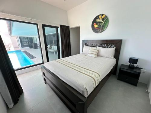 a bedroom with a large bed and a swimming pool at Bure 30 Luxury Villa in Nadi