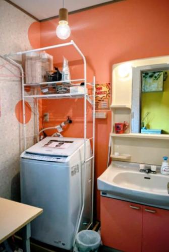 a small kitchen with a sink and a washing machine at Fuji Hike Stay in Oyama
