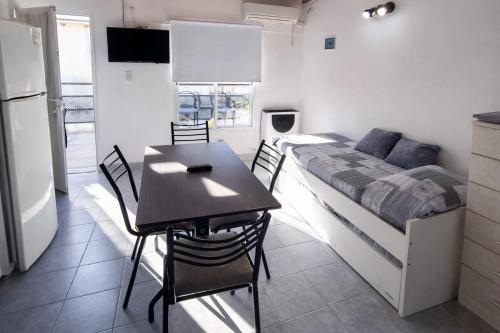 a kitchen and dining room with a table and a bed at Gotas de Rocío - Balcón para 4 in San Antonio Oeste