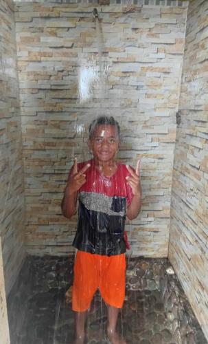 a woman standing in a shower with her hands up at LOwayalailaiSTAY in Wayasewa Island