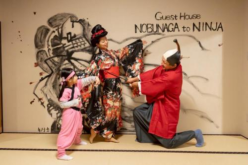 a man and two women and a child performing a performance at 旅宿信長と忍者---1階-信長の間---NOBUNAGAtoNINJA in Omihachiman