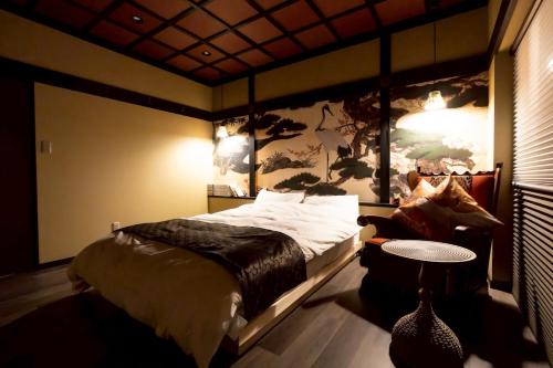 a bedroom with a bed with a large painting on the wall at 旅宿信長と忍者---1階-信長の間---NOBUNAGAtoNINJA in Omihachiman