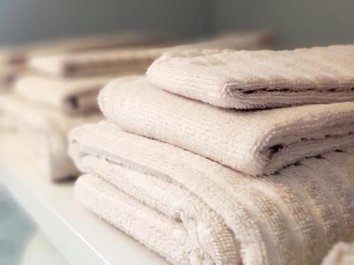 a stack of white towels on a shelf with books at Appartamento La Corte in Inveruno
