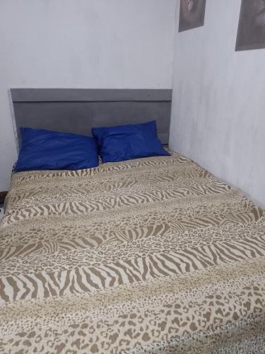 a bed with a blue pillow on top of it at Passeio de quadriciclo com hospedagem in Guapimirim