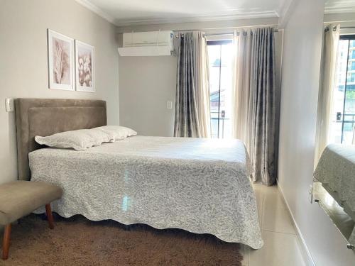 a bedroom with a bed and a window at Apartamento 3 Quartos - Centro de Piratuba in Piratuba