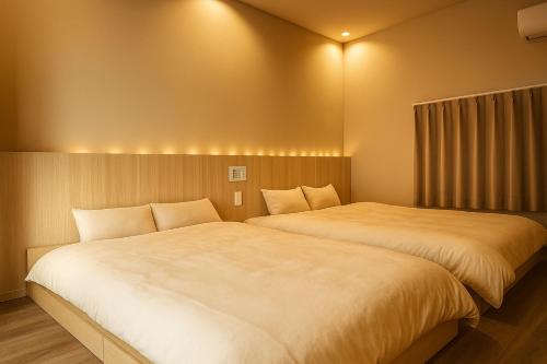 two beds sitting next to each other in a room at 滋庵 jian okayama in Okayama