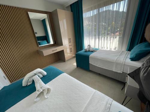 a hotel room with two beds and a mirror at Lina Life in Fethiye