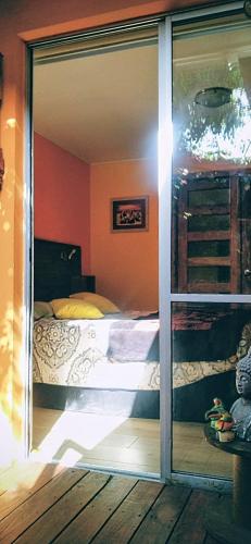 a bedroom with a bed through a sliding glass door at La Casa de los Cactus in Coquimbo