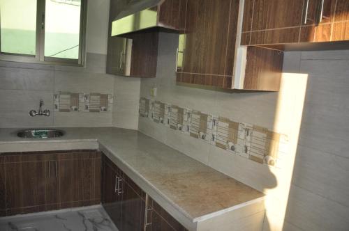 a kitchen with wooden cabinets and a sink at Ayub Residence Bhurban in Murree