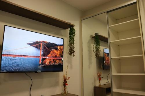 a flat screen tv hanging on a wall in a living room at Studio no Sudoeste, vista da 1ª Avenida, tudo a pé in Brasília