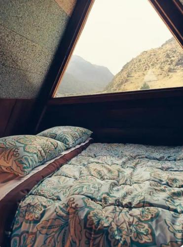a bed sitting in a room with a window at Raíces de Papallacta in Papallacta
