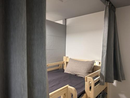 a bedroom with a bunk bed with a curtain at 女性専用 dormitory all good in Miyako-jima