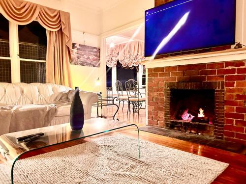 a living room with a fireplace with a tv above it at The Sister Cottage in Kalorama