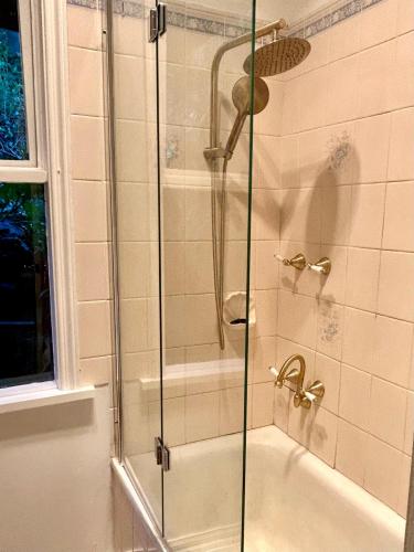a shower with a glass door in a bathroom at Stillwaters in Kalorama
