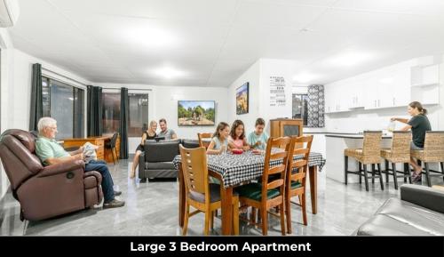 a group of people sitting around a table in a room at Aaron Motel in Gladstone