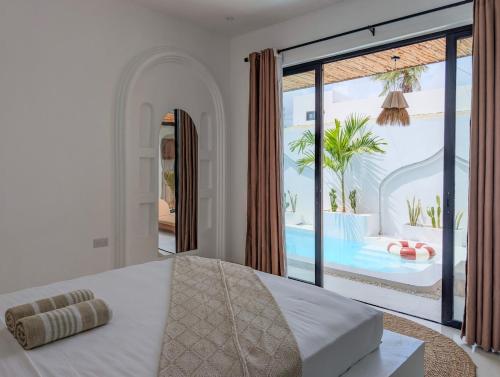 a bedroom with a bed and a view of a pool at Marram Villas 3 Prime Location in Paje