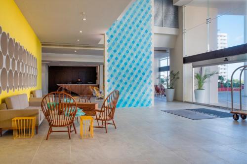 a lobby with chairs and a table in a building at Krystal Urban Cancun & Beach Club in Cancún
