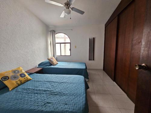 a bedroom with two beds and a ceiling fan at Casa FLAMINGOS in Boca del Río