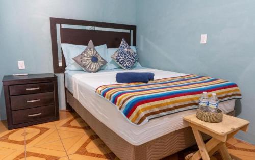 a bedroom with a large bed with a wooden table at POSADA CENTRO MAZUNTE RINCONCITo in Mazunte