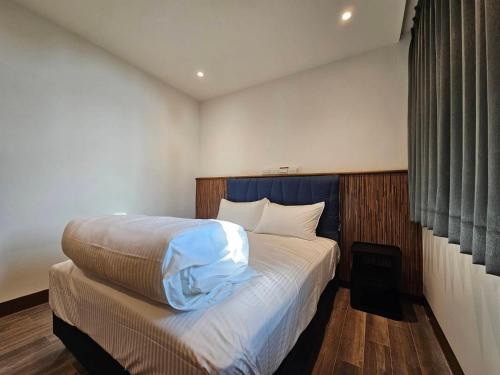 una camera da letto con un grande letto con testiera blu di meet happiness a Hsia-pu-hsia