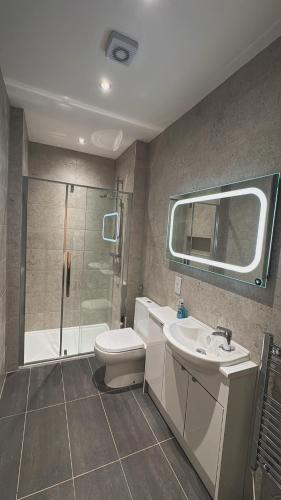 a bathroom with a shower and a toilet and a sink at Edinburgh West Residence in Edinburgh