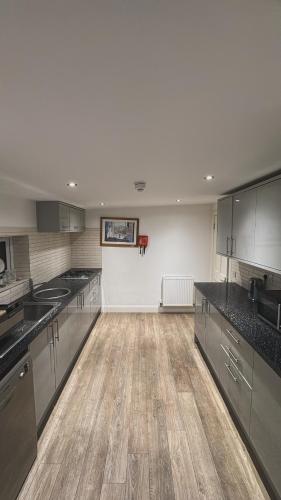 a large kitchen with wooden floors and stainless steel appliances at Edinburgh West Residence in Edinburgh