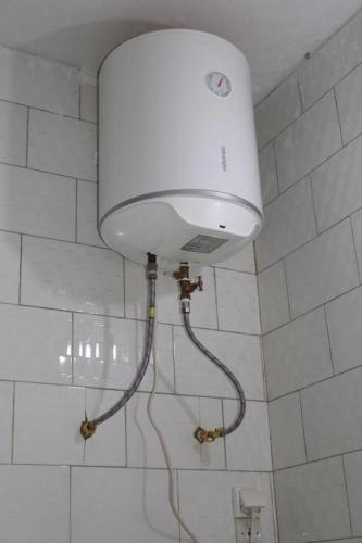 a white light on the wall of a bathroom at 1 lit en dortoir partagé - Résidences PRIMIS Thiès in Thies