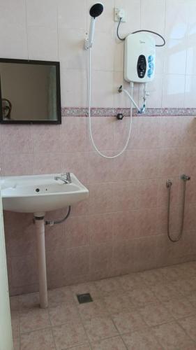 a bathroom with a shower and a sink and a mirror at BB Hotel in Gerik