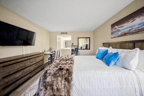 a bedroom with a large bed with a flat screen tv at Lux Mins To Atrium Health and Downtown Airport in Charlotte