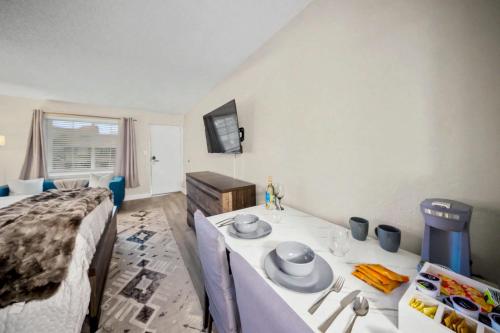 a room with a bed and a table with plates and dishes on it at Lux Mins To Atrium Health and Downtown Airport in Charlotte