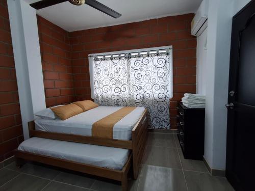 a small bedroom with a bed and a window at Cabañas Mar Caribe in Necoclí