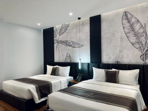 two beds in a hotel room with a mural at LION 12 Hotel in Can Tho