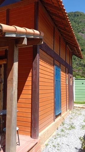 a wooden building with blue doors on the side of it at Cabana Jandaia in Teresópolis