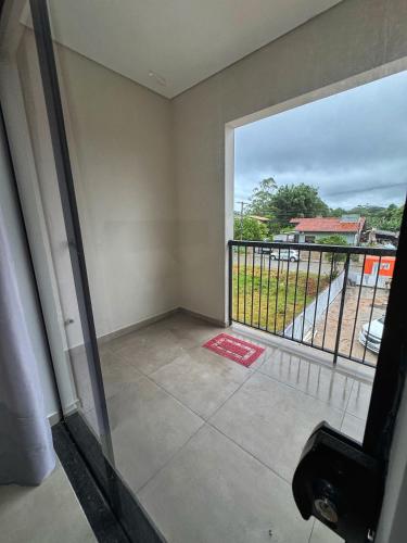 a room with a balcony with a large window at Pousada Ebenezer in Garopaba
