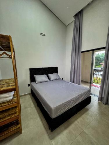 a bedroom with a bed and a window at Pousada Ebenezer in Garopaba